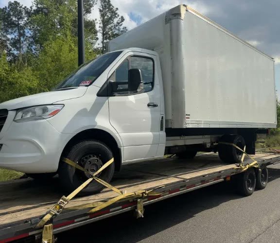 Box truck secured on flatbed trailer