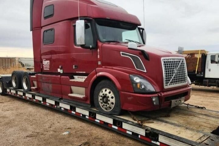 Semi truck loaded for transport on RGN trailer